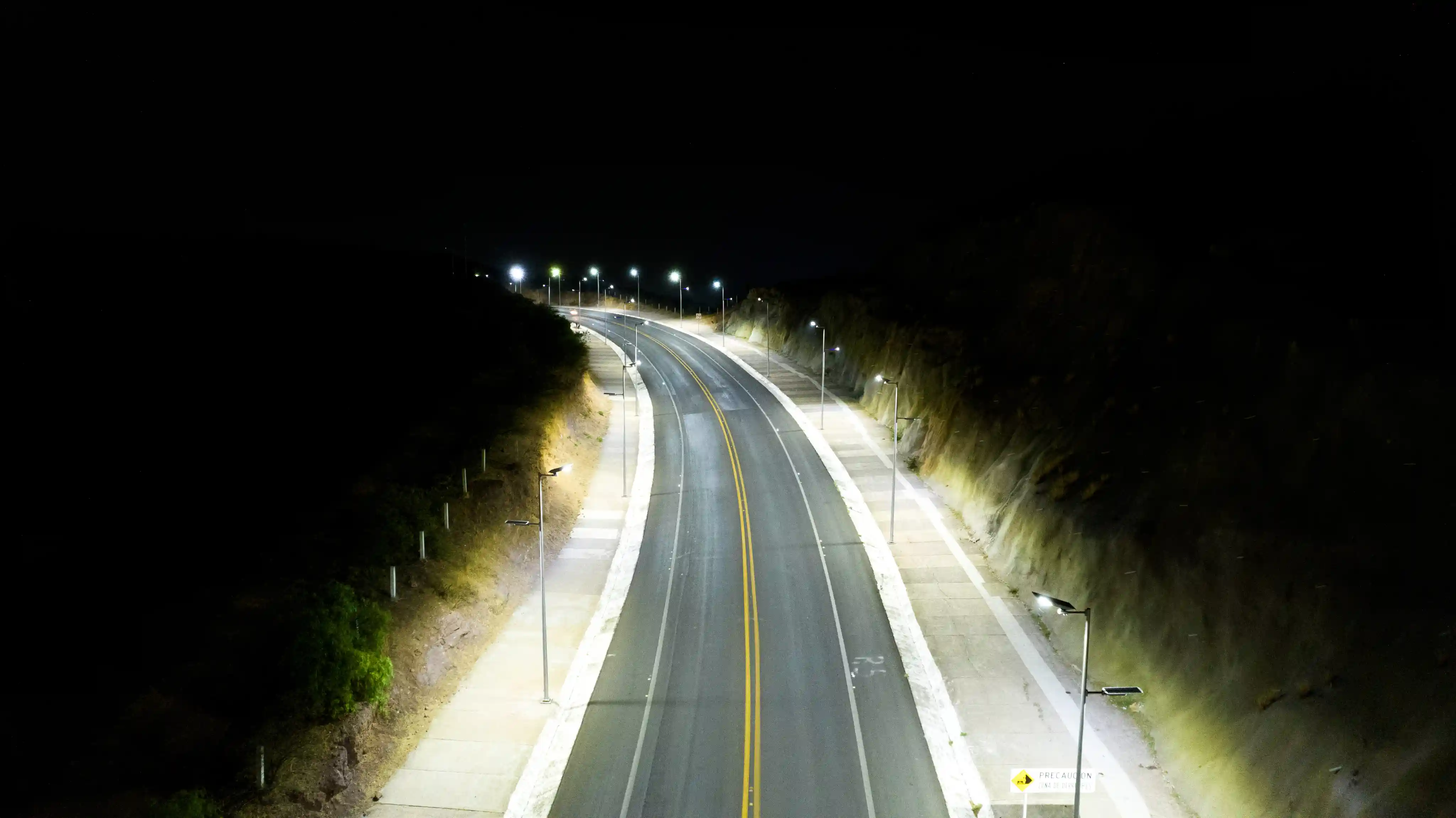 Vialidad iluminada de noche con lámparas resistentes